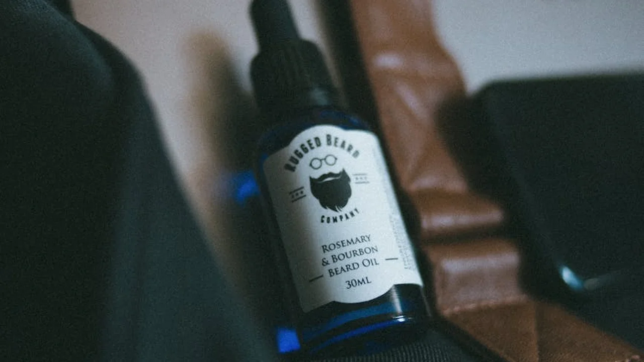 Blue glass bottle with dropper labeled beard oil on a dark background