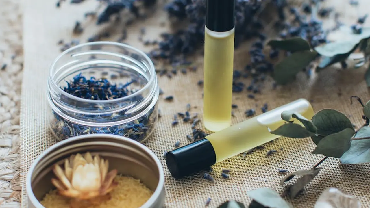 Close-up of black cumin seeds and a dropper bottle of oil on a textured surface, illustrating product selection for black cumin seed oil.