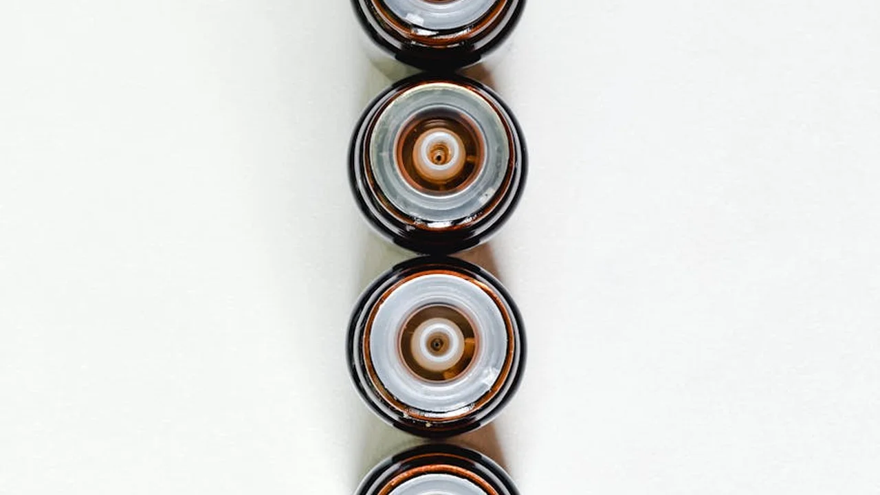Vertical row of small brown glass dropper bottles on a white background, representing botanical alternatives to neem oil for garden pest control.