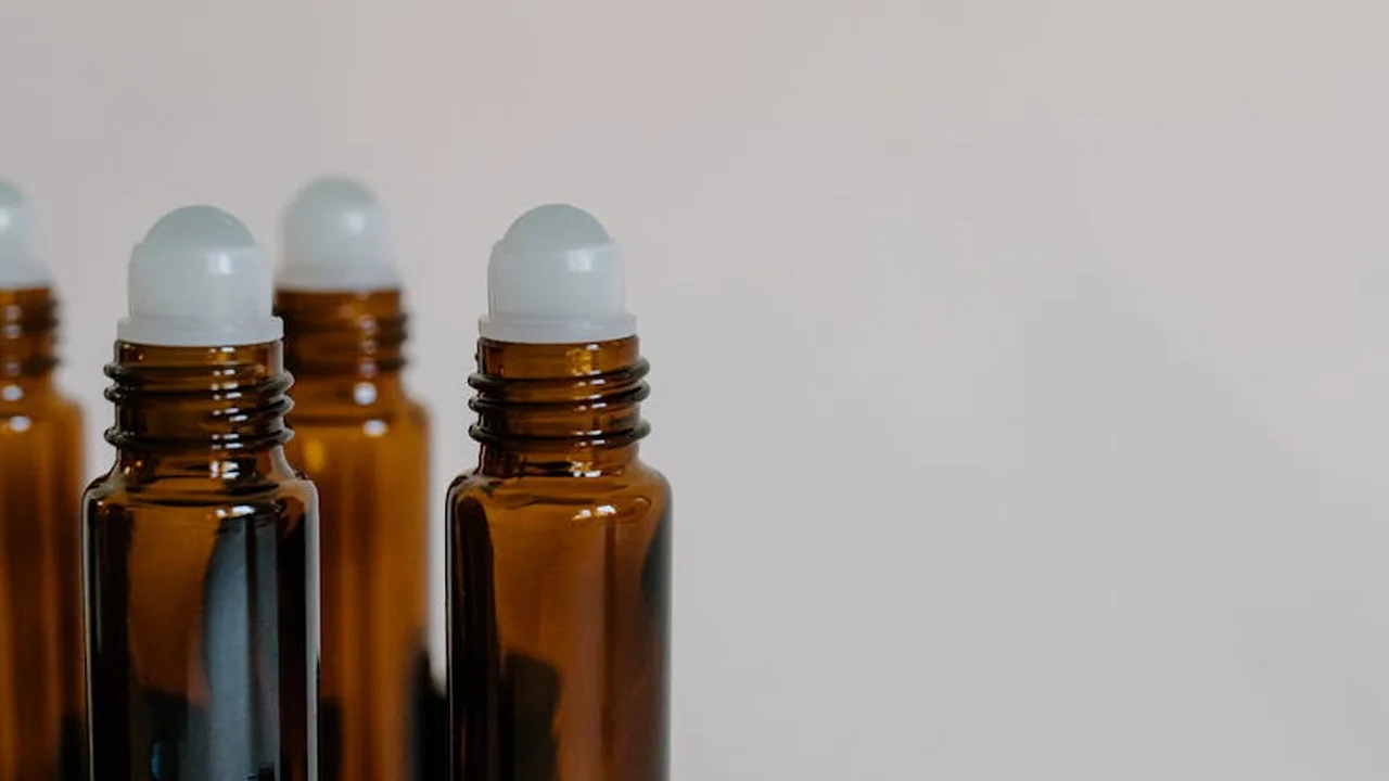 Amber glass bottles with dropper caps arranged on a neutral background, used for essential or botanical oils