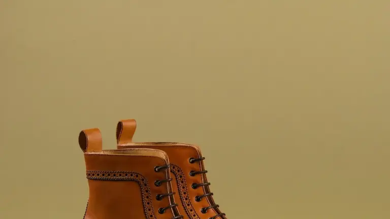 Brown leather lace-up boot on a neutral beige background