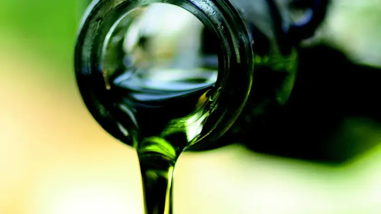 Close-up of oil pouring from a bottle, illustrating carrier oils used in skincare.