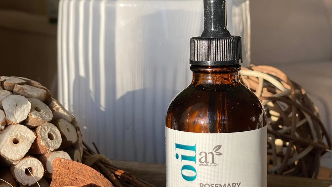 Amber glass dropper bottle of castor oil with a white label, beside a woven decorative ball and natural wood textures.