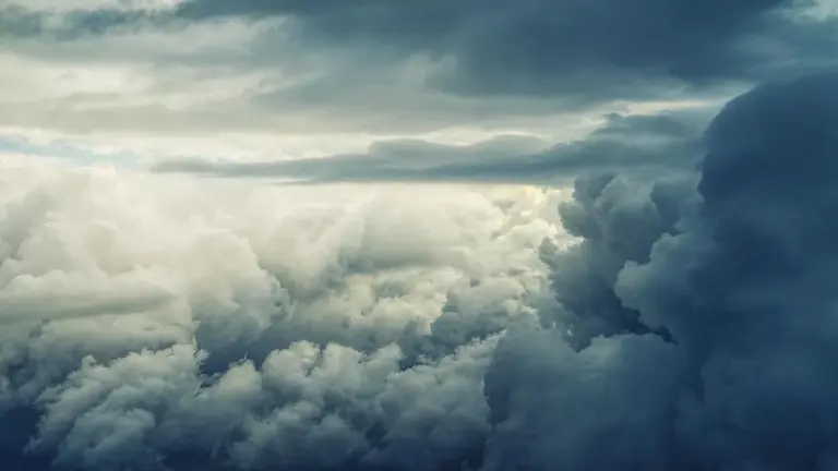 Dramatic cloudscape with white and gray cumulus clouds filling the sky.