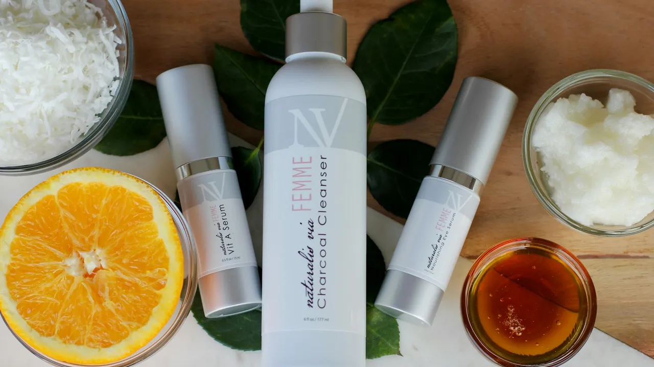 Flat lay of coconut oil bottles and related ingredients on a wooden surface, including an orange half and shredded coconut.