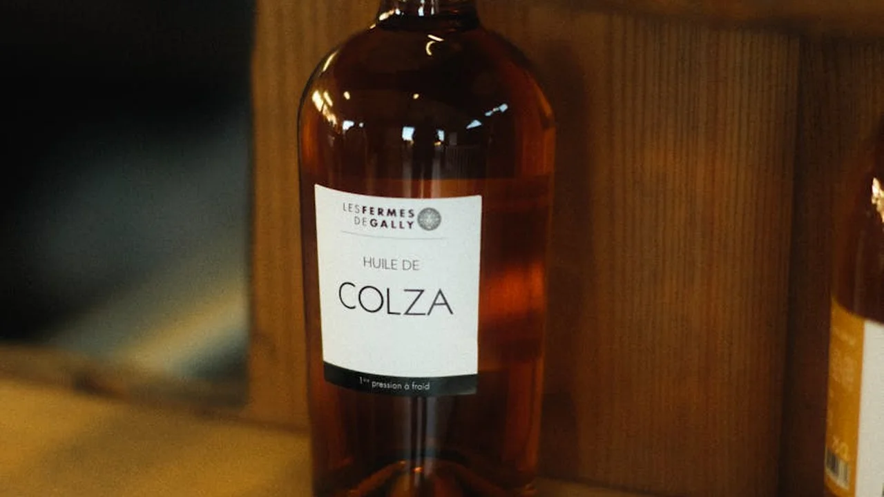 Close-up of a bottle labeled 'Huile de Colza' (rapeseed oil) on a wooden surface