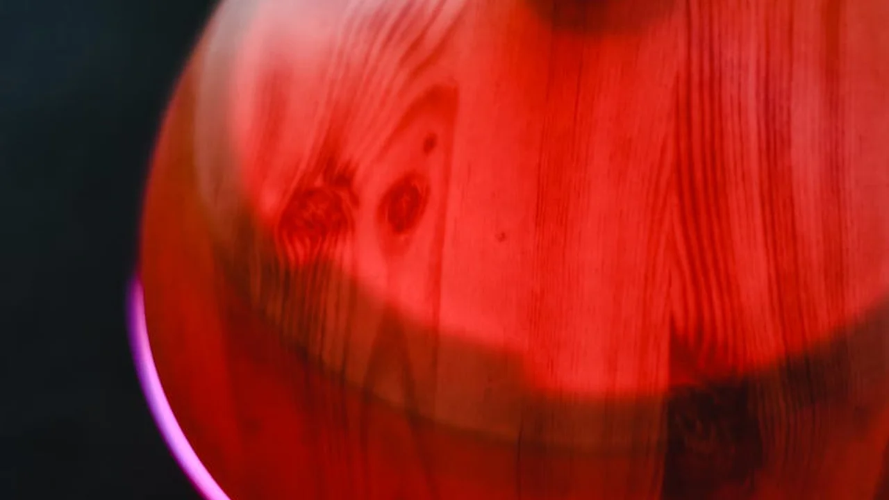 Close-up of a red glowing diffuser with a subtle purple accent light.
