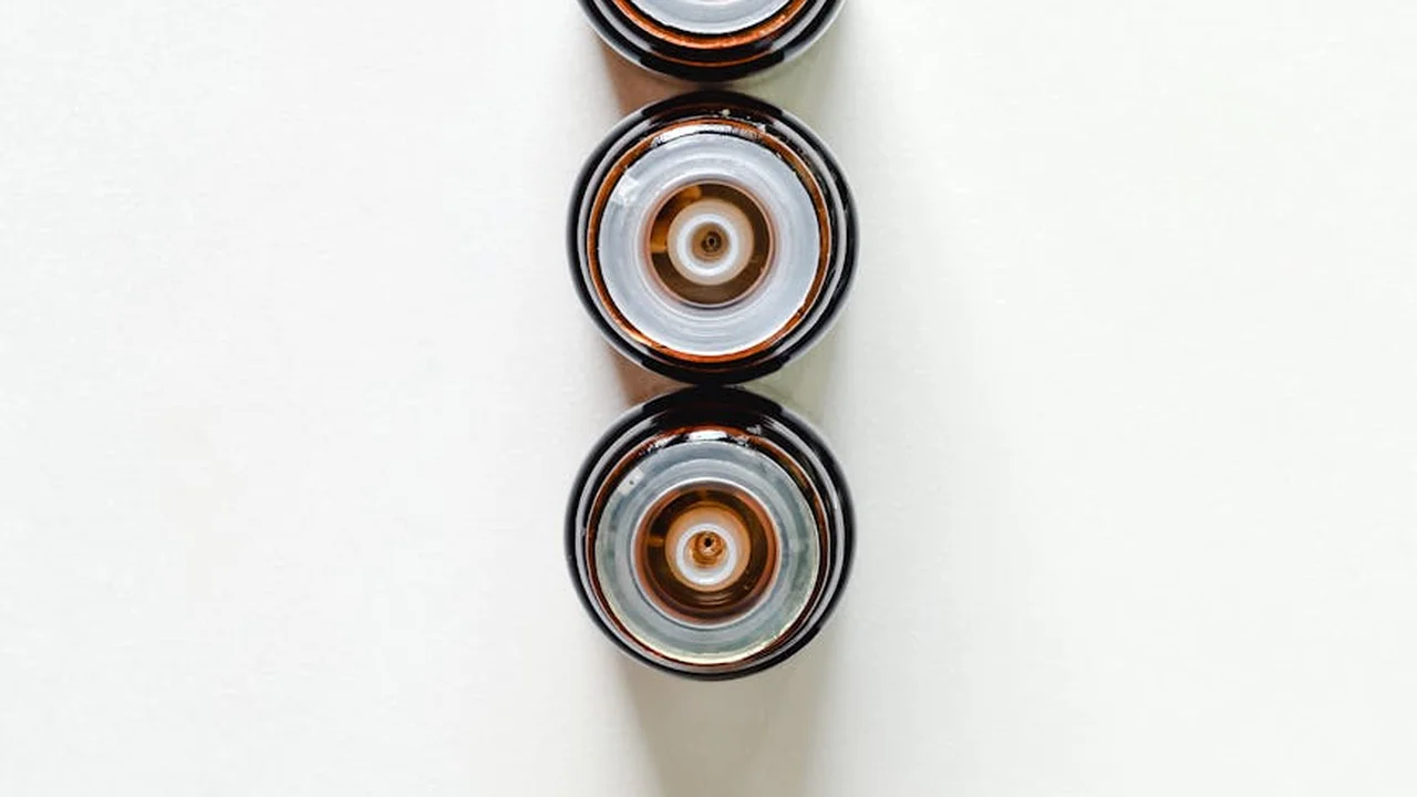 Three brown glass dropper bottles lined up on a white background