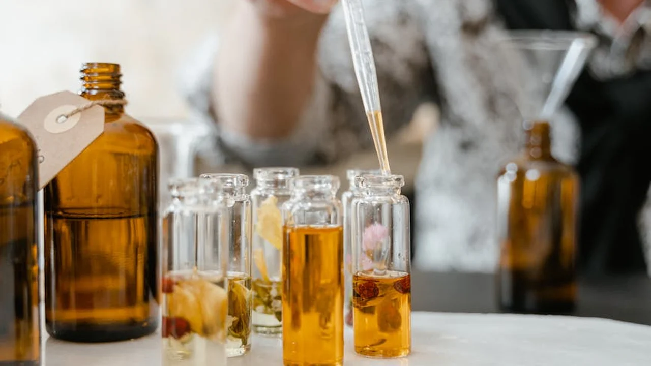 Amber glass bottles of essential oils with a dropper ready for blending in a skincare setup.
