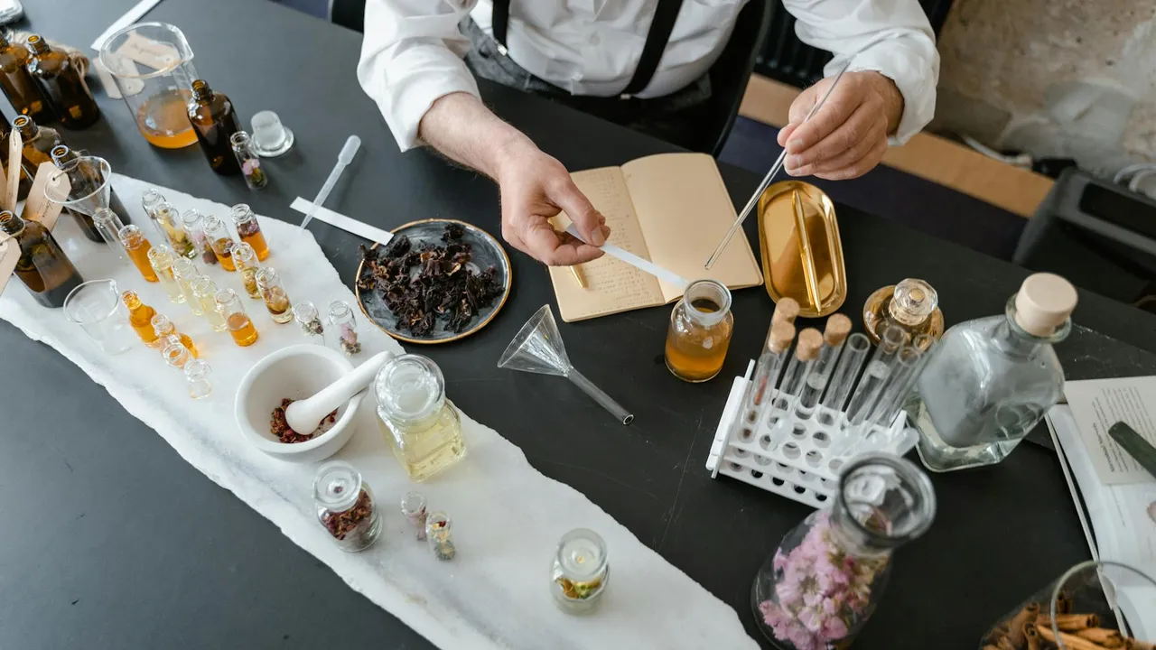 Lab workspace with essential oil bottles, glassware, and a technician handling a sample.