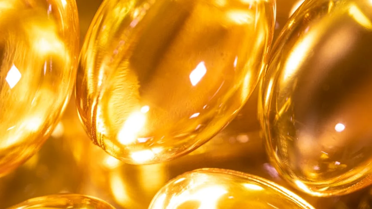Close-up of glossy gold fish oil capsules
