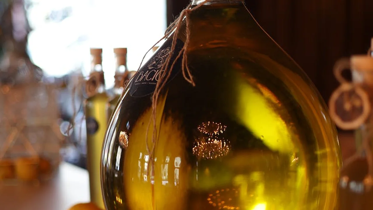 Close-up of a bottle of cooking oil with warm golden light, illustrating the optimal frying temperature range for oil longevity.