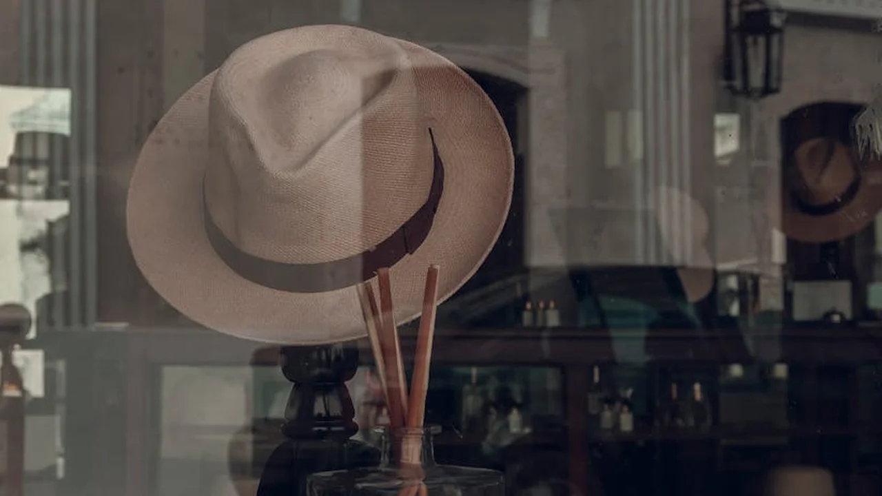 Storefront window displaying wide-brimmed hats with reflections