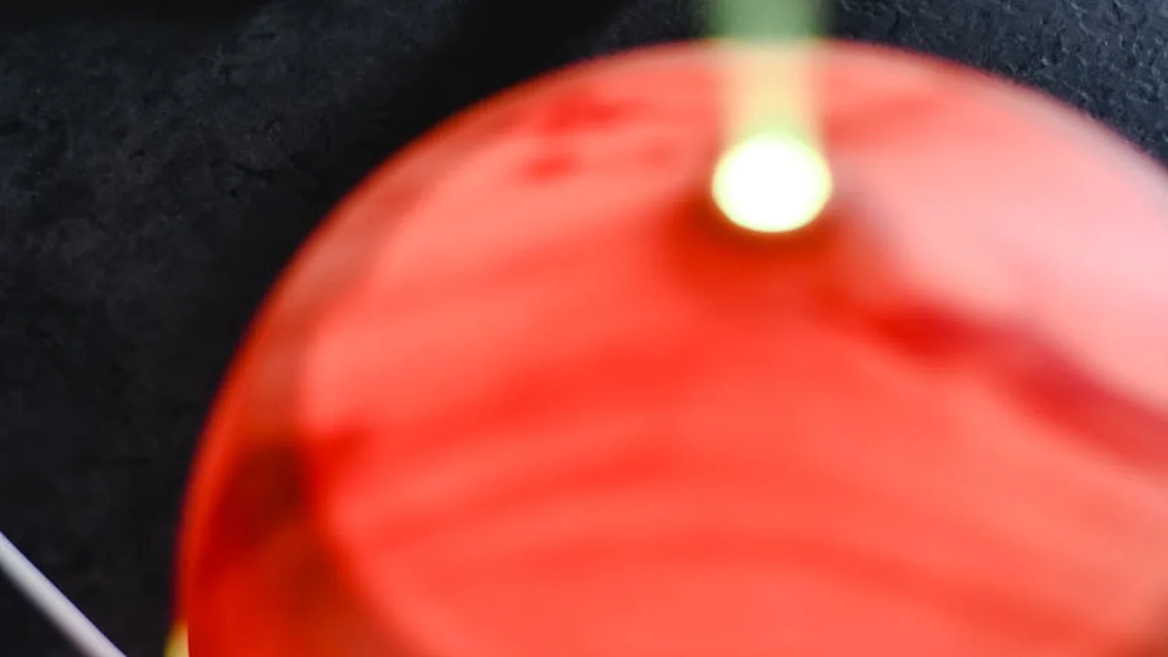 Close-up of a red diffuser or essential oil burner emitting a warm glow against a dark background.