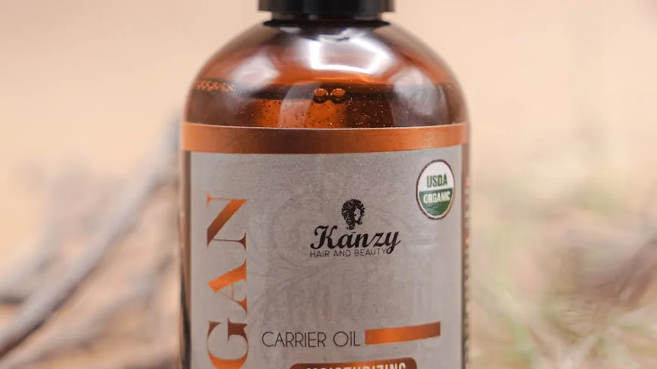 Brown glass carrier oil bottle with label and USDA Organic badge on a warm, blurred background.