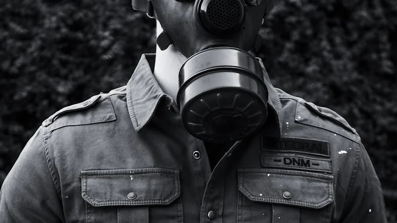 A person wearing a gas mask in a grayscale portrait.