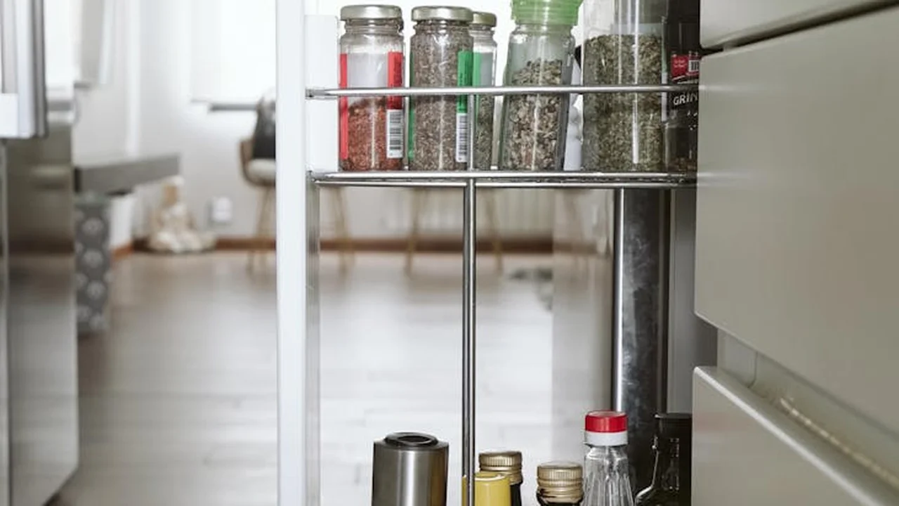 Inside a refrigerator with metal racks holding glass spice jars and oil bottles, illustrating organized oil storage.
