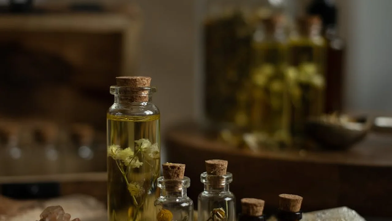Glass oil bottles with cork stoppers on a kitchen counter with a blurred background.