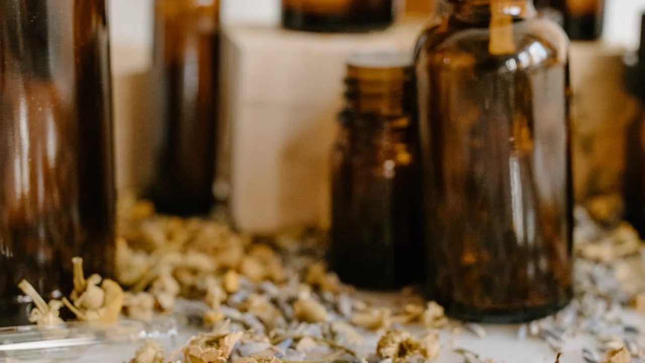 Amber glass oil bottles on a kitchen counter with garlic scattered nearby.