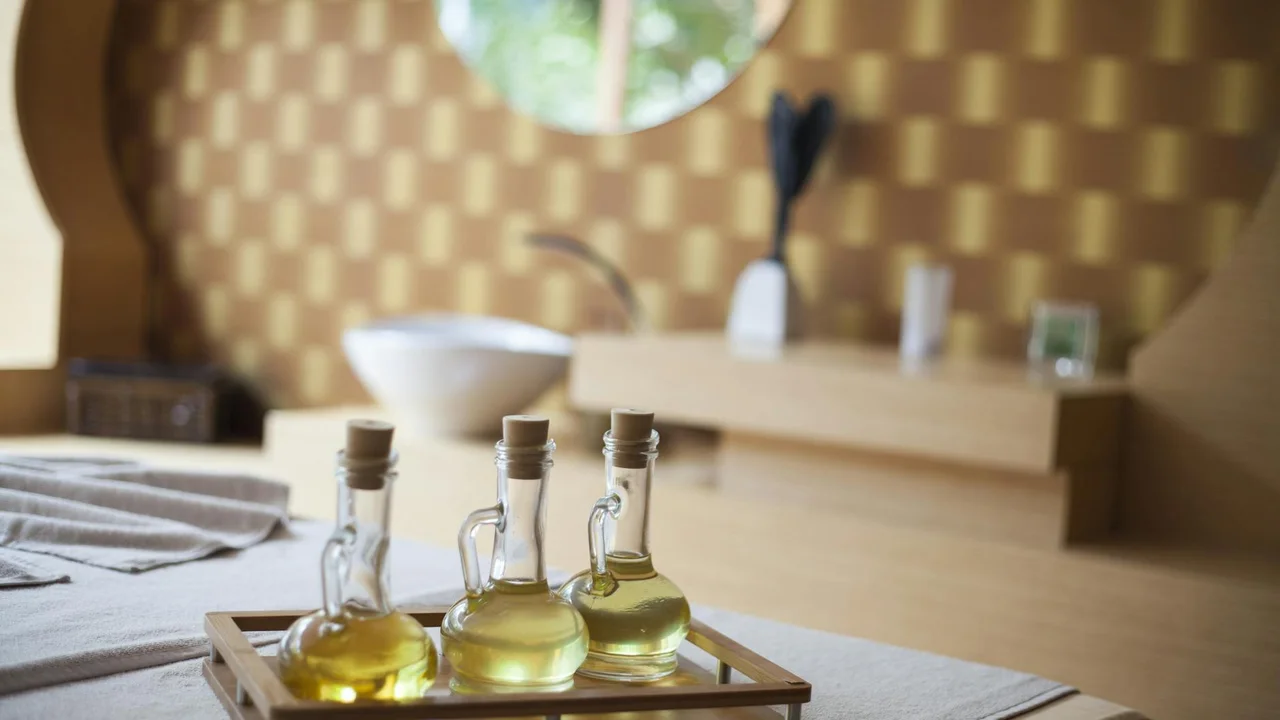 Olive oil bottles in a wooden tray on a kitchen counter with a blurred kitchen background