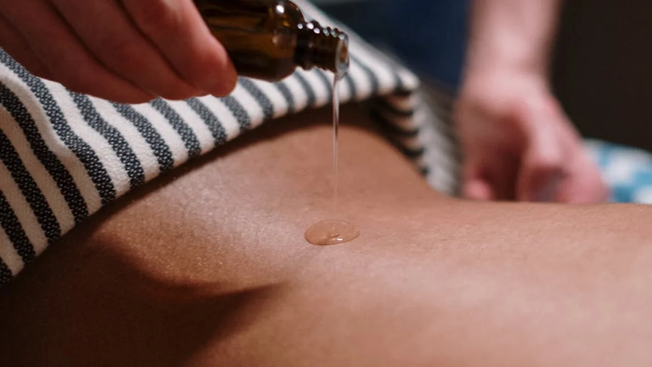 Close-up of a dropper releasing oil onto skin for a patch test