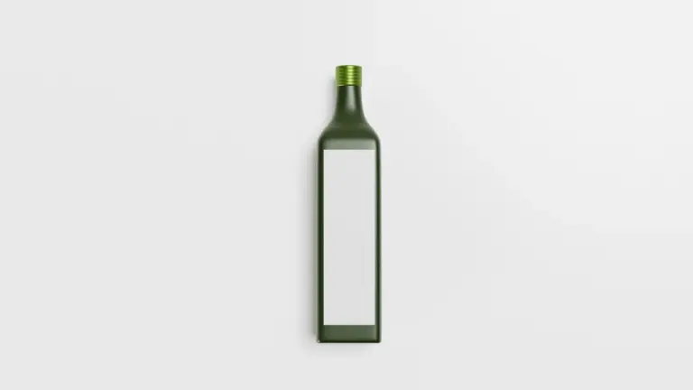 Green glass oil bottle with a blank label on a white background