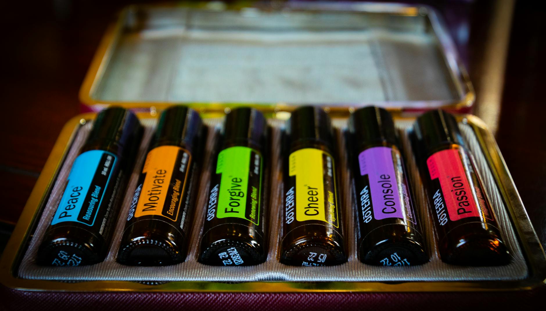Smiling woman with a towel wrapped around her head, applying foamy face wash in a bathroom.