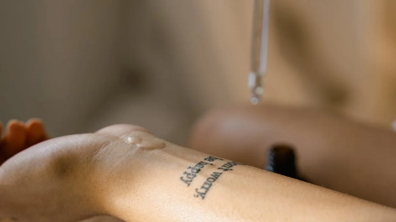 Close-up of a forearm with a drop of liquid near the skin, illustrating shaving oil application for sensitive skin