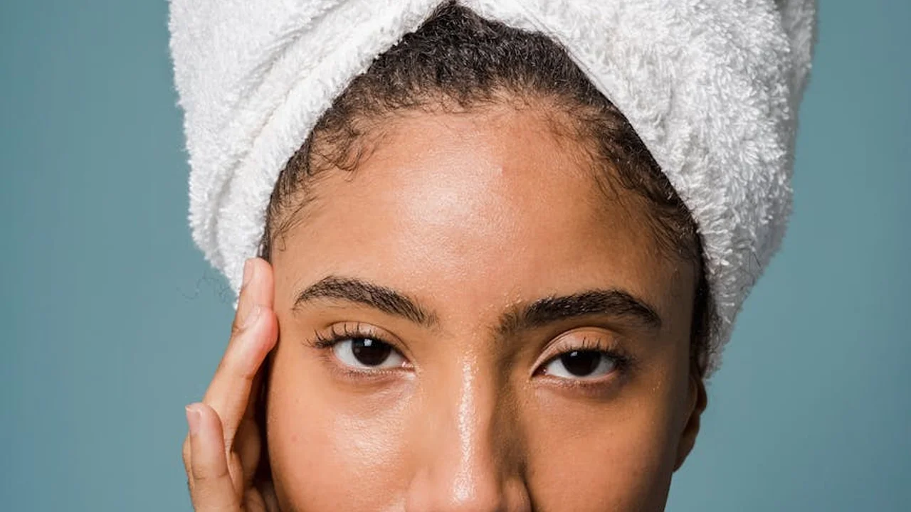 Woman with a towel wrapped around her head, preparing to start a skincare regimen.