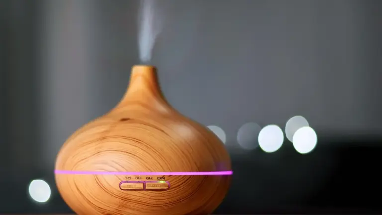 Woodgrain essential oil diffuser emitting vapor with a purple ring of light.
